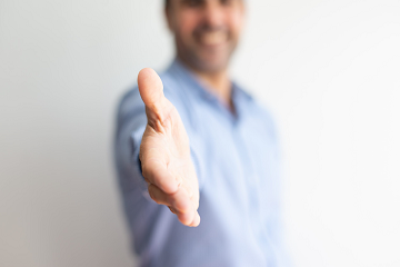 Hombre sonriendo y ofreciendo la mano